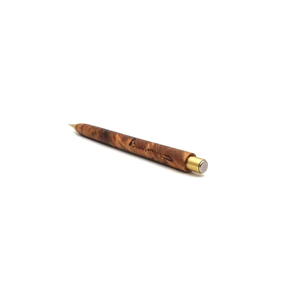 Angled view of a Nicholas Hemingway handmade mechanical pencil in Camphor Burl with solid brass hardware, featuring the maker's signature on the figured wood barrel.